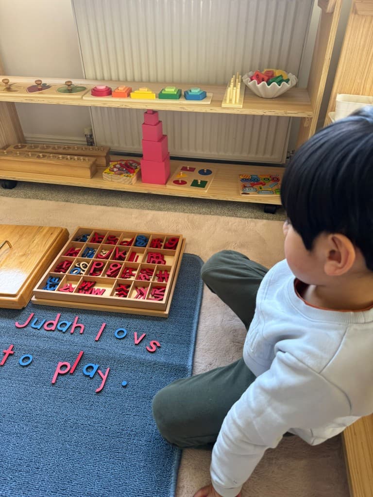 Child spelling a sentence with moveable alphabet