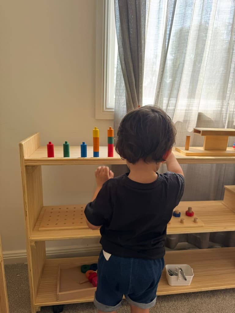Toddler stacking and sorting at Montessori shelf