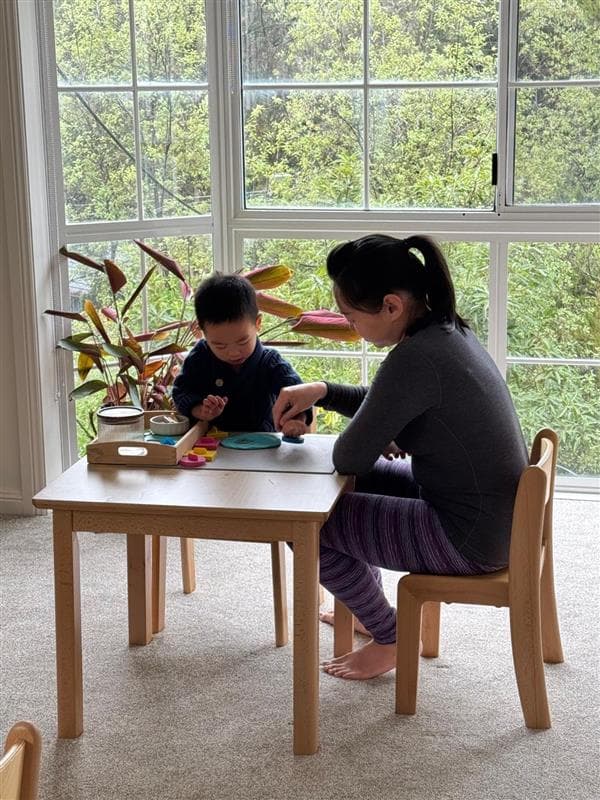Parent and child working together at a Montessori table